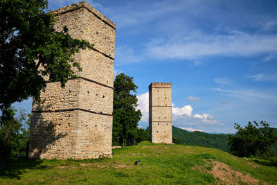 Old castle on field against sky