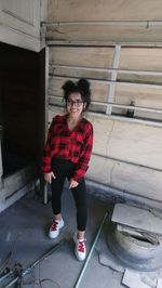 Portrait of smiling woman standing against wall