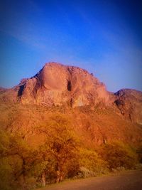 Scenic shot of rocky mountains against clear blue sky