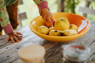 Midsection of woman with fruits on table