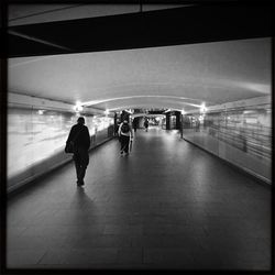 People walking in illuminated tunnel