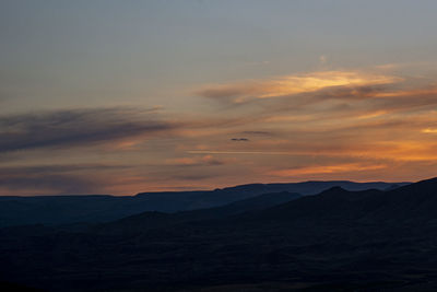 Scenic view of silhouette mountains against sky during sunset