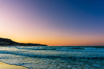 Scenic view of sea against clear sky at sunset