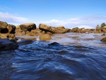 Rocks in sea against sky