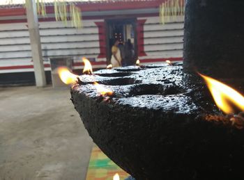 Close-up of burning candle on retaining wall