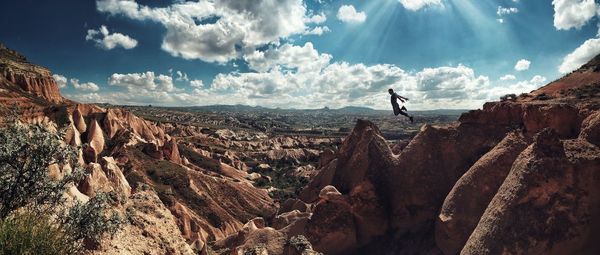 Man jumping from rock formations at cavusin