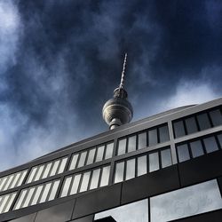 Low angle view of modern building by fernsehturm against sky