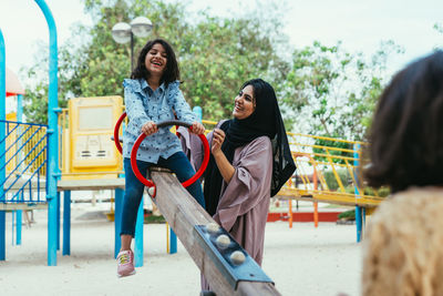 Mother with cheerful daughters enjoying at park