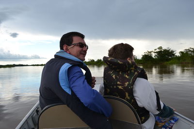 Man sitting with son in boat on lake