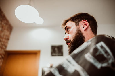 Portrait of young man looking away at home