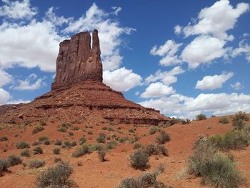 View of rock formations in desert against cloudy sky