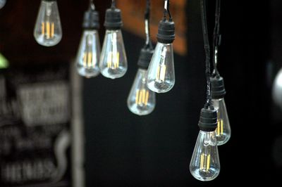 Close-up of light bulbs hanging outdoors