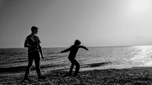 Full length of children on beach against sky