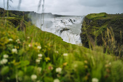 Scenic view of waterfall against sky