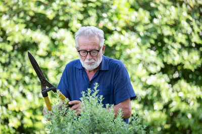 Portrait of man wearing hat holding plants
