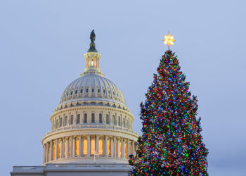 Low angle view of christmas tree against blue sky