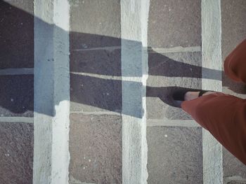 Low section of man standing on road