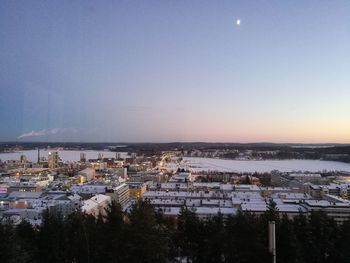 Cityscape by sea against clear sky