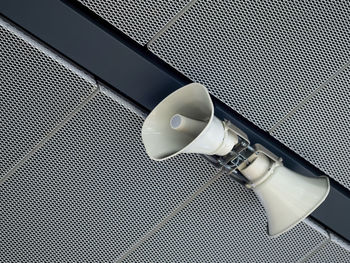 View of twin megaphones hanging from ceiling. waiting for travel in the train station