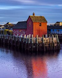 Row of houses by sea against sky