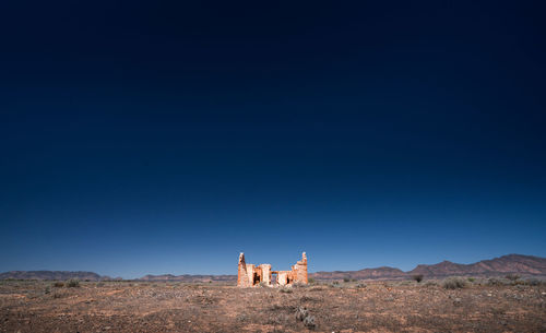 Ruined structure against clear blue sky