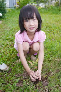 Portrait of a smiling girl on grassy field