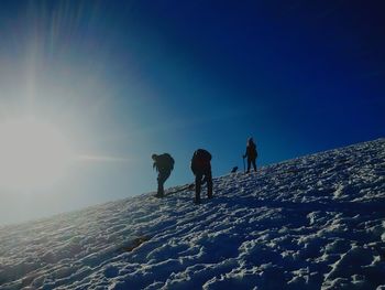 Low angle view of people walking on snow covered landscape