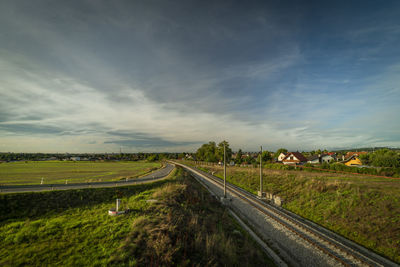 Road amidst field against sky