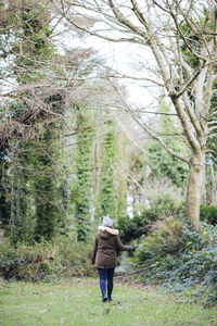 Rear view of woman walking in forest