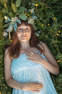 Portrait of young woman standing against plants