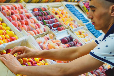 Cropped hand of woman holding fruits for sale