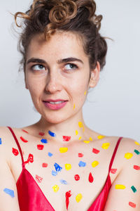 Close-up of woman with paint against white background