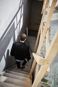 High angle view of architect moving down on steps at construction site