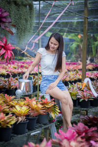 Portrait of smiling woman with flowers in garden