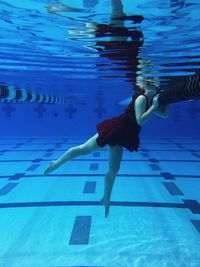 Low section of man swimming in pool