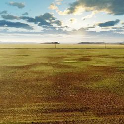 Scenic view of field against cloudy sky