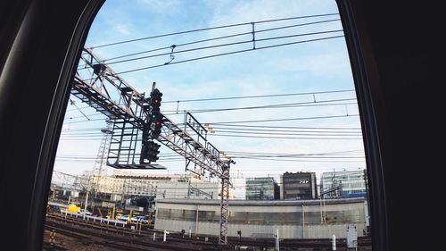 Electricity pylon in city against sky