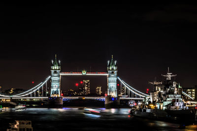 Illuminated tower bridge over thames river in city at night