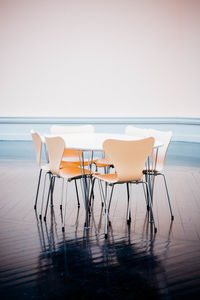 Empty chairs and table in sea