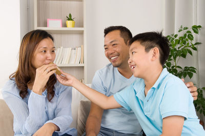 Happy family sitting on sofa at home