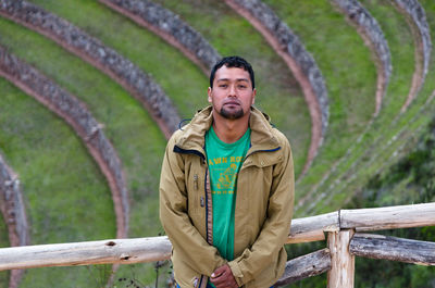 Portrait of young man standing against amphitheater