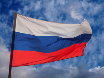 Low angle view of flag against blue sky