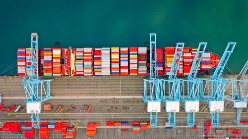 Multi colored chairs at commercial dock against blue sky