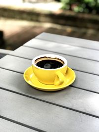 Close-up of yellow coffee cup on table