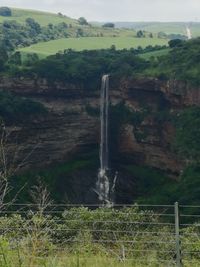 Scenic view of waterfall against sky