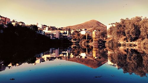 Panoramic view of lake and buildings against clear sky