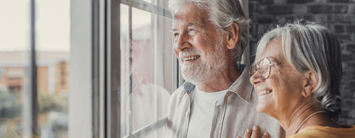 Side view of young man looking through window