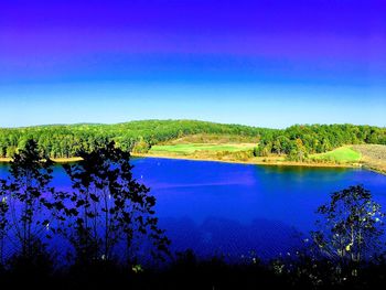 Scenic view of lake against clear blue sky