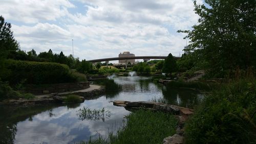 Bridge over river against cloudy sky