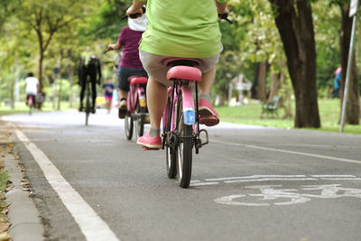 Low section of man riding bicycle on road